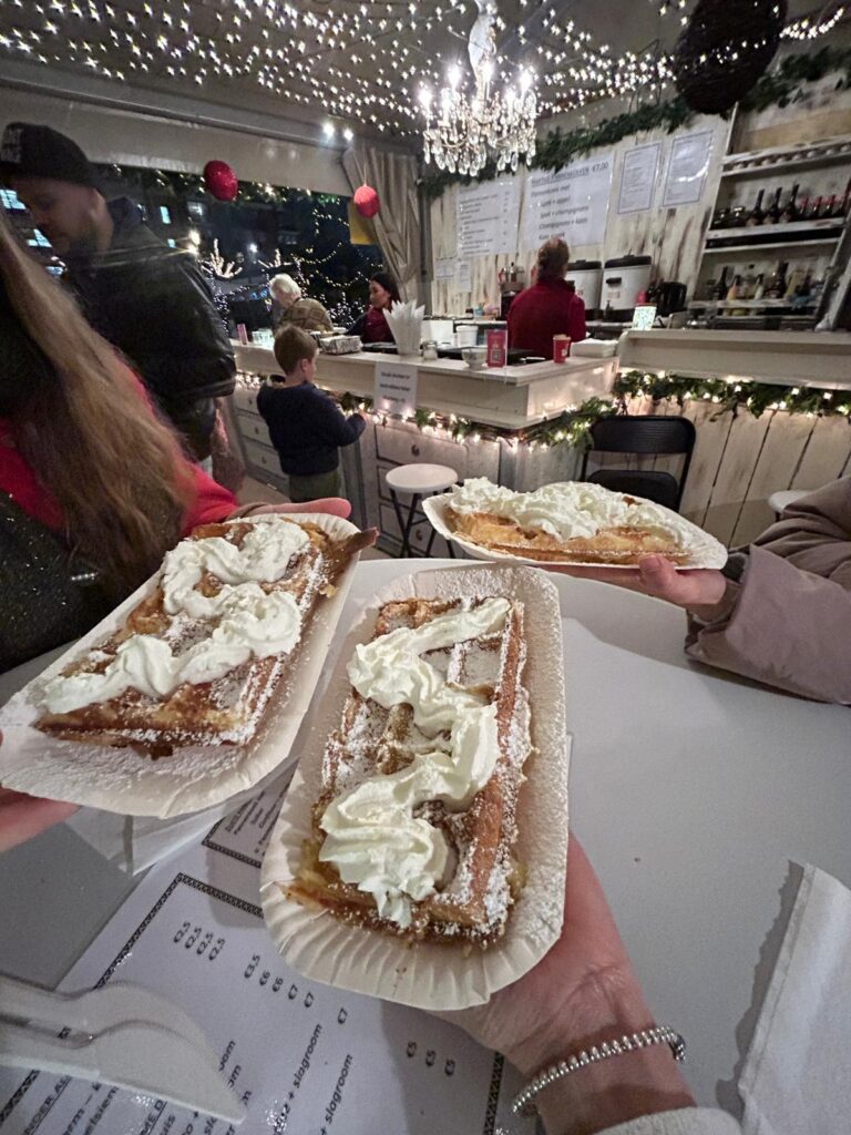 3 hands holding waffels on paper plates