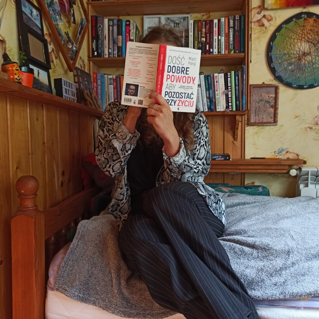 girl sitting on bed holding book